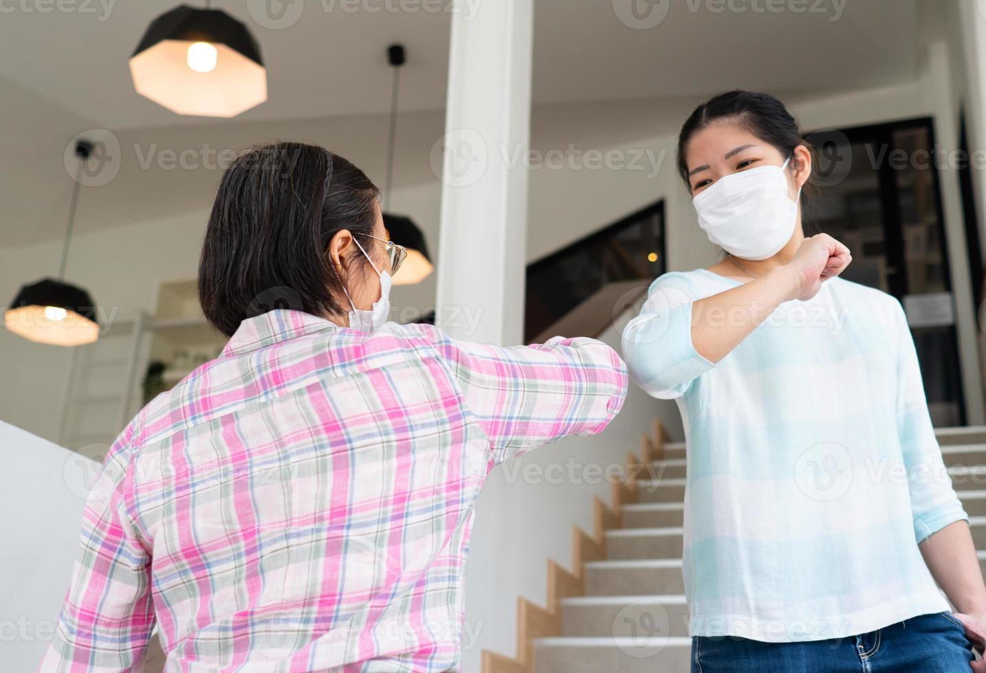 mensen die masker dragen en elleboog stoten tijdens pandemie foto