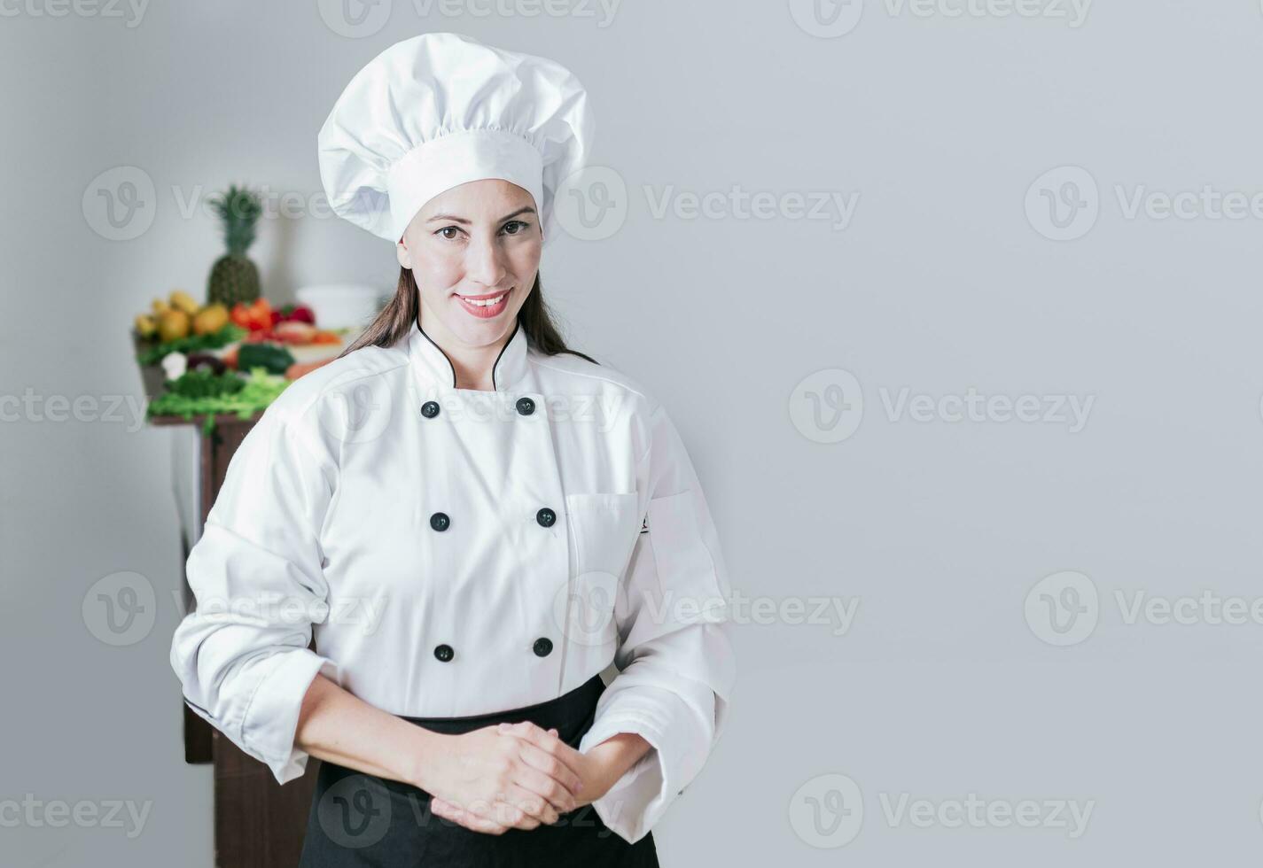 portret van een vrouw chef omringd door vers groenten, portret van een vrouw voedingsdeskundige in uniform met vers groenten Aan de tafel, een vrouw voedingsdeskundige met een tafel van groenten foto