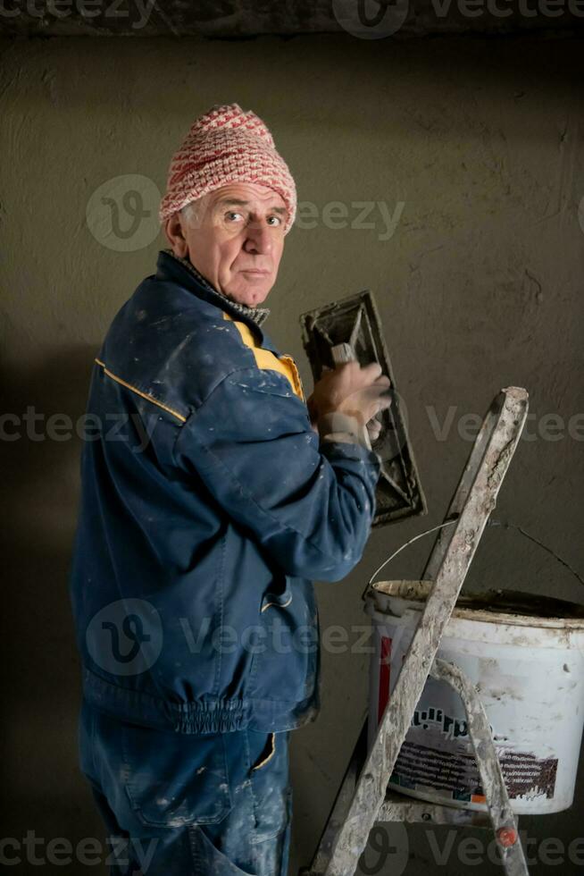 arbeider bepleistering de muur door beton foto