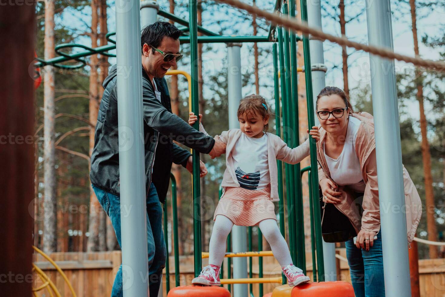 familie pret in de park. gelukkig familie uitgeven tijd in park en spelen met hun dochter foto