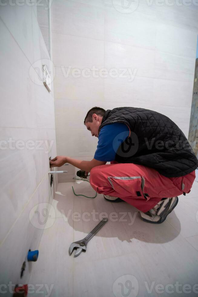 professioneel loodgieter werken in een badkamer foto