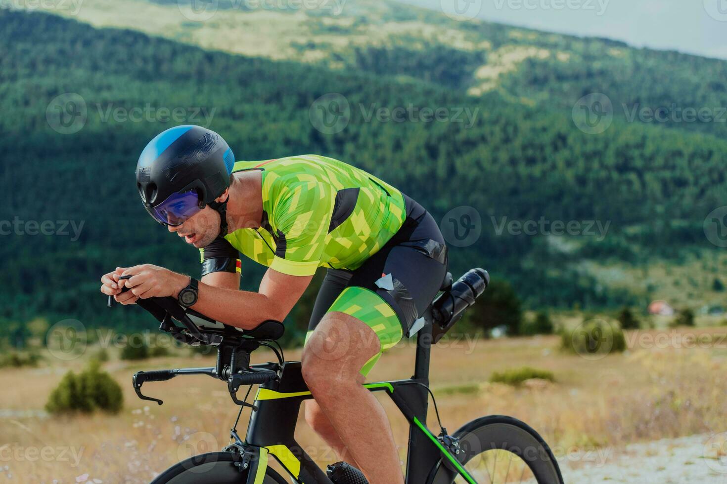 vol lengte portret van een actief triatleet in sportkleding en met een beschermend helm rijden een fiets. selectief focus foto