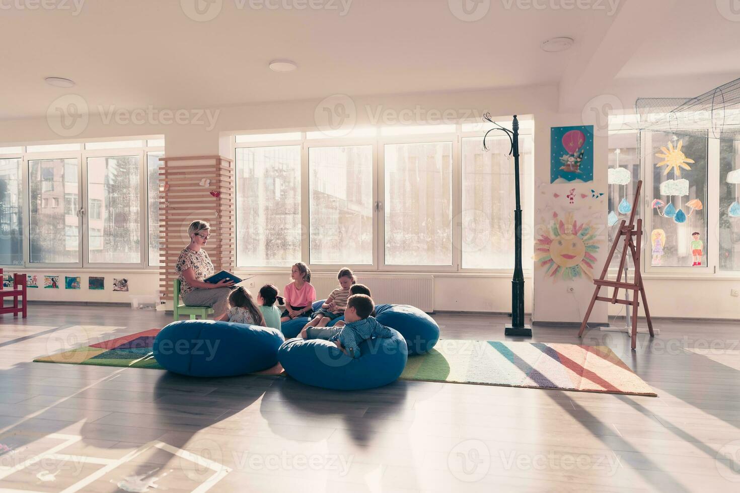 lezing tijd in elementair school- of kleuterschool, leraar lezing een boek naar kinderen in elementair school- of kindergaden. selectief focus foto