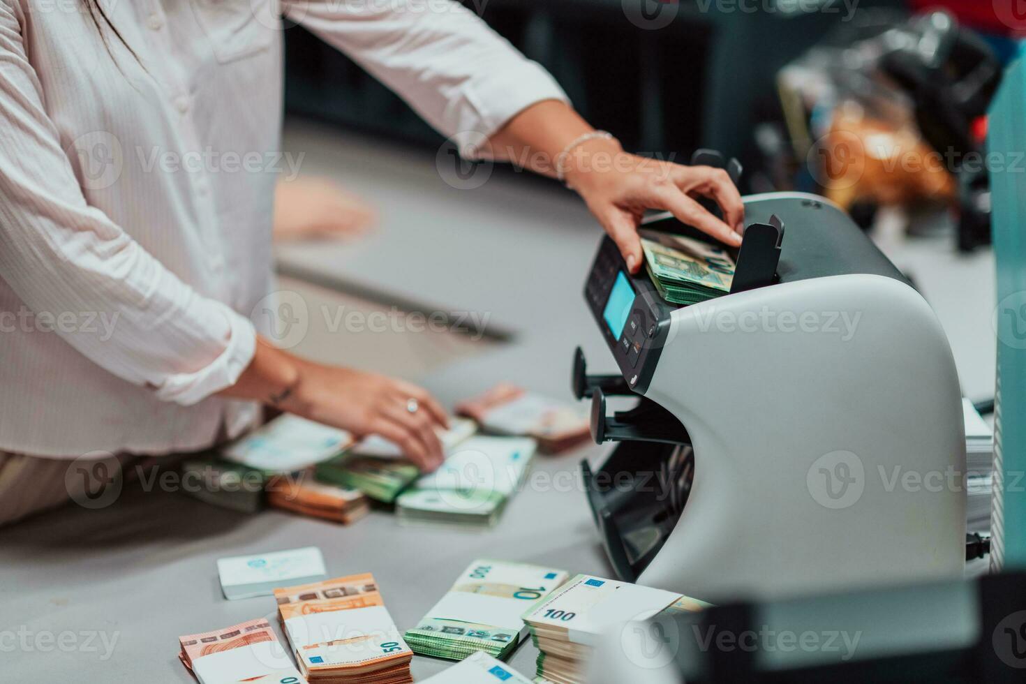 bank medewerkers gebruik makend van geld tellen machine terwijl sorteren en tellen papier bankbiljetten binnen bank kluis. groot bedragen van geld in de bank foto