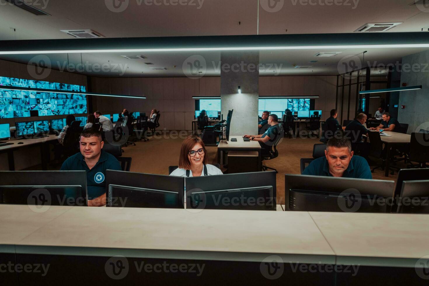 groep van veiligheid gegevens centrum operators werken in een cctv toezicht houden kamer op zoek Aan meerdere monitoren officieren toezicht houden meerdere schermen voor verdacht activiteiten team werken Aan de systeem controle foto