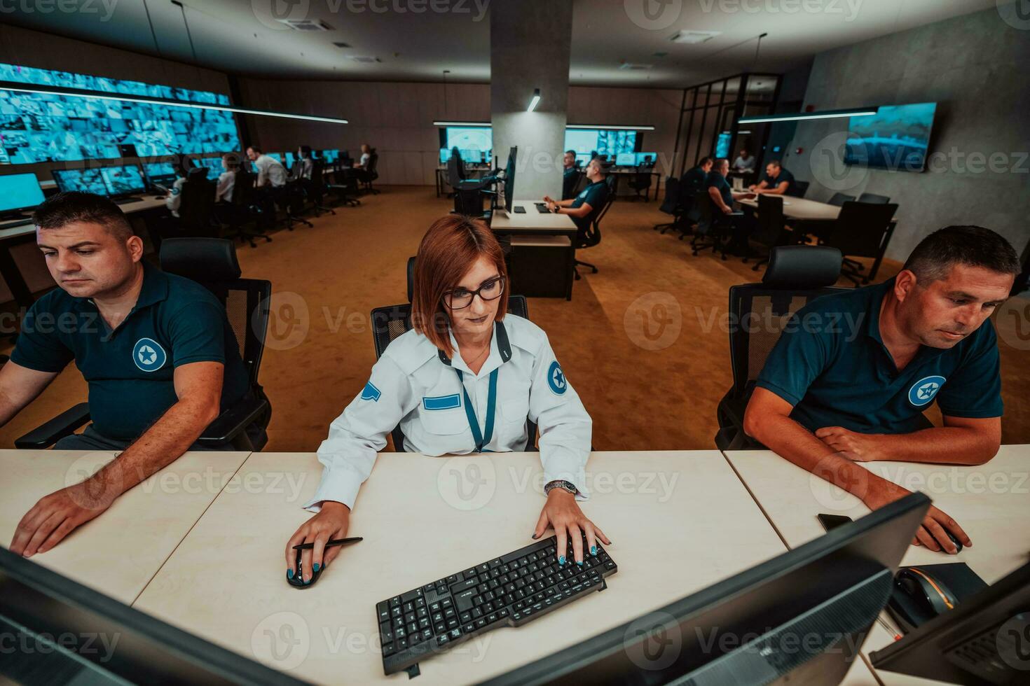 groep van veiligheid gegevens centrum operators werken in een cctv toezicht houden kamer op zoek Aan meerdere monitoren officieren toezicht houden meerdere schermen voor verdacht activiteiten team werken Aan de systeem controle foto