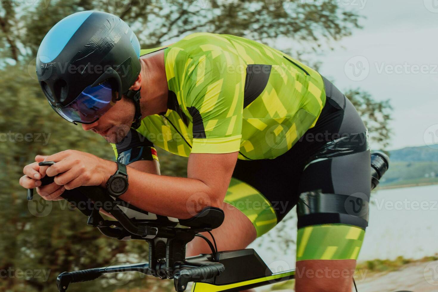 dichtbij omhoog foto van een actief triatleet in sportkleding en met een beschermend helm rijden een fiets. selectief focus