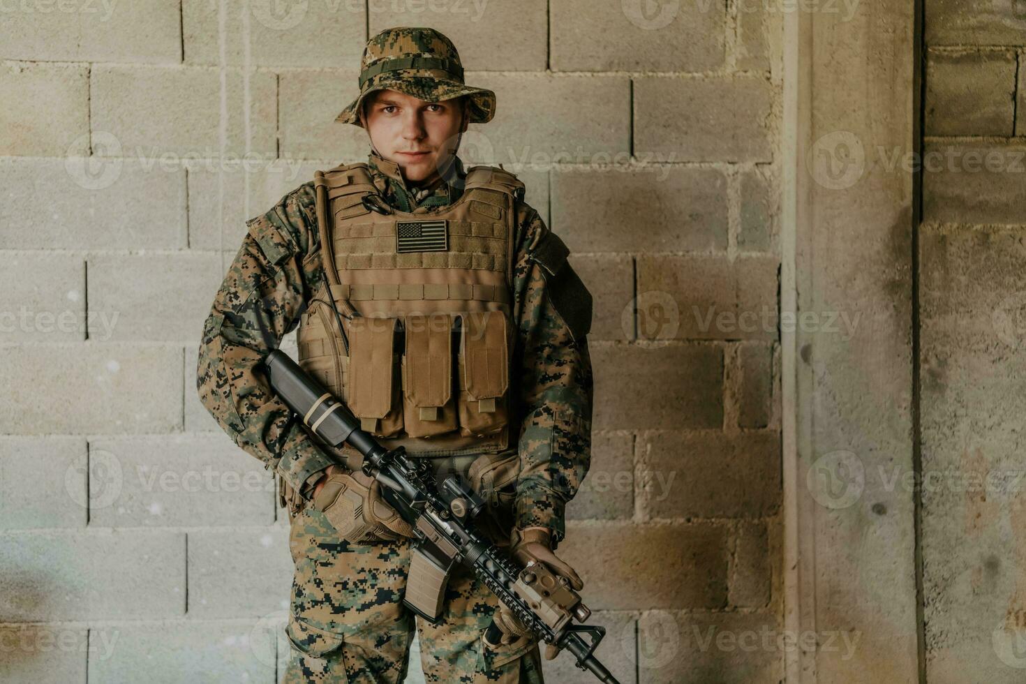 een soldaat in uniform staat in voorkant van een steen muur in vol oorlog uitrusting voorbereidingen treffen voor strijd foto