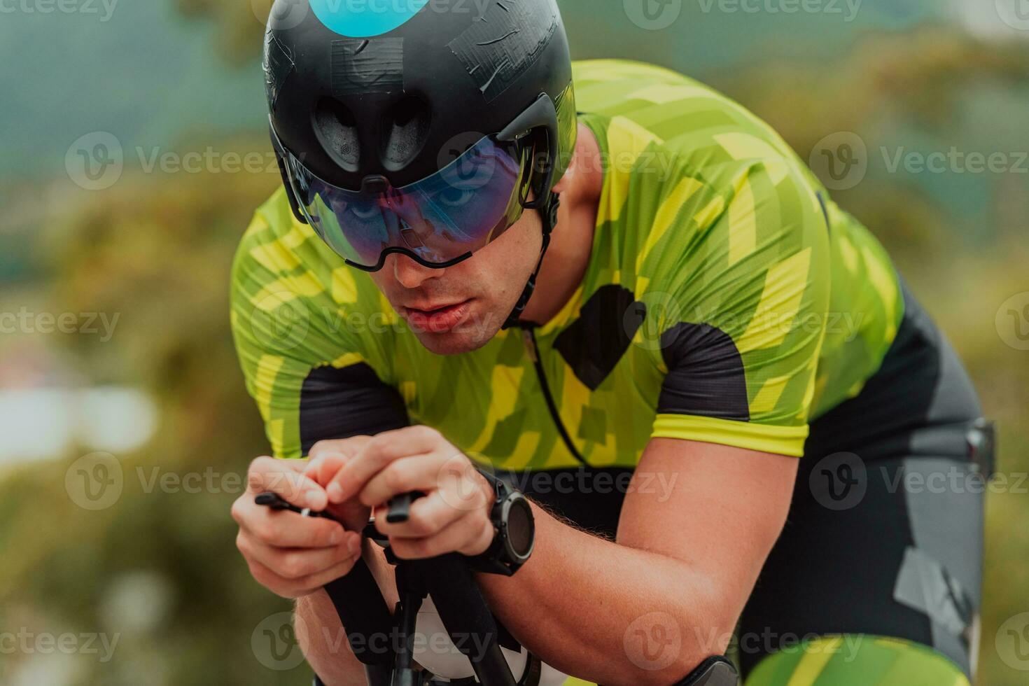 dichtbij omhoog foto van een actief triatleet in sportkleding en met een beschermend helm rijden een fiets. selectief focus