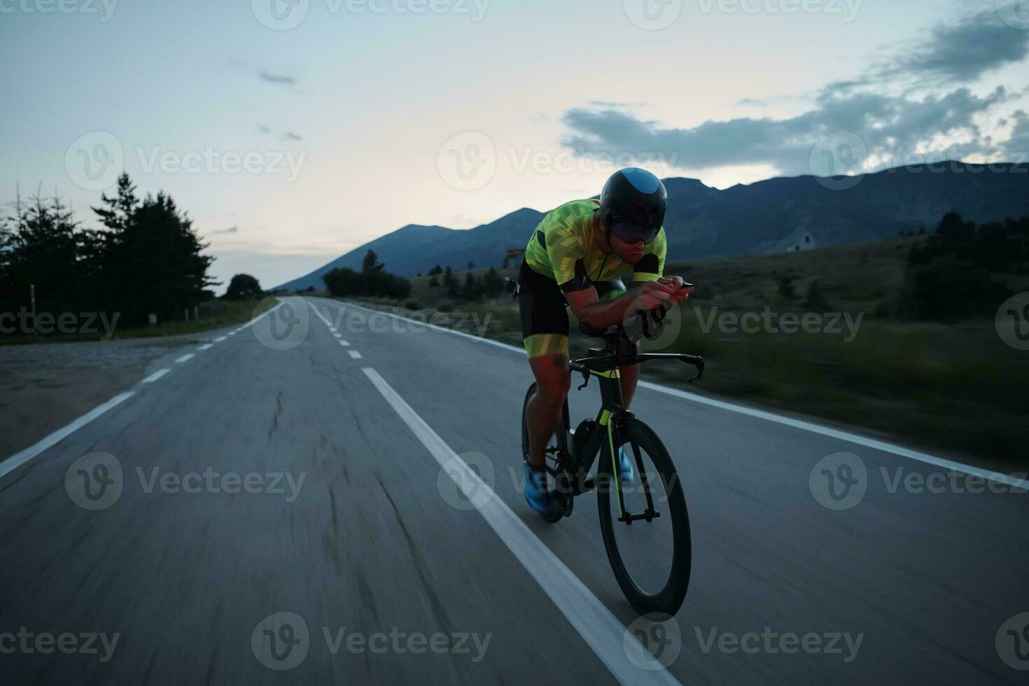 triatlonatleet die 's nachts fietst foto