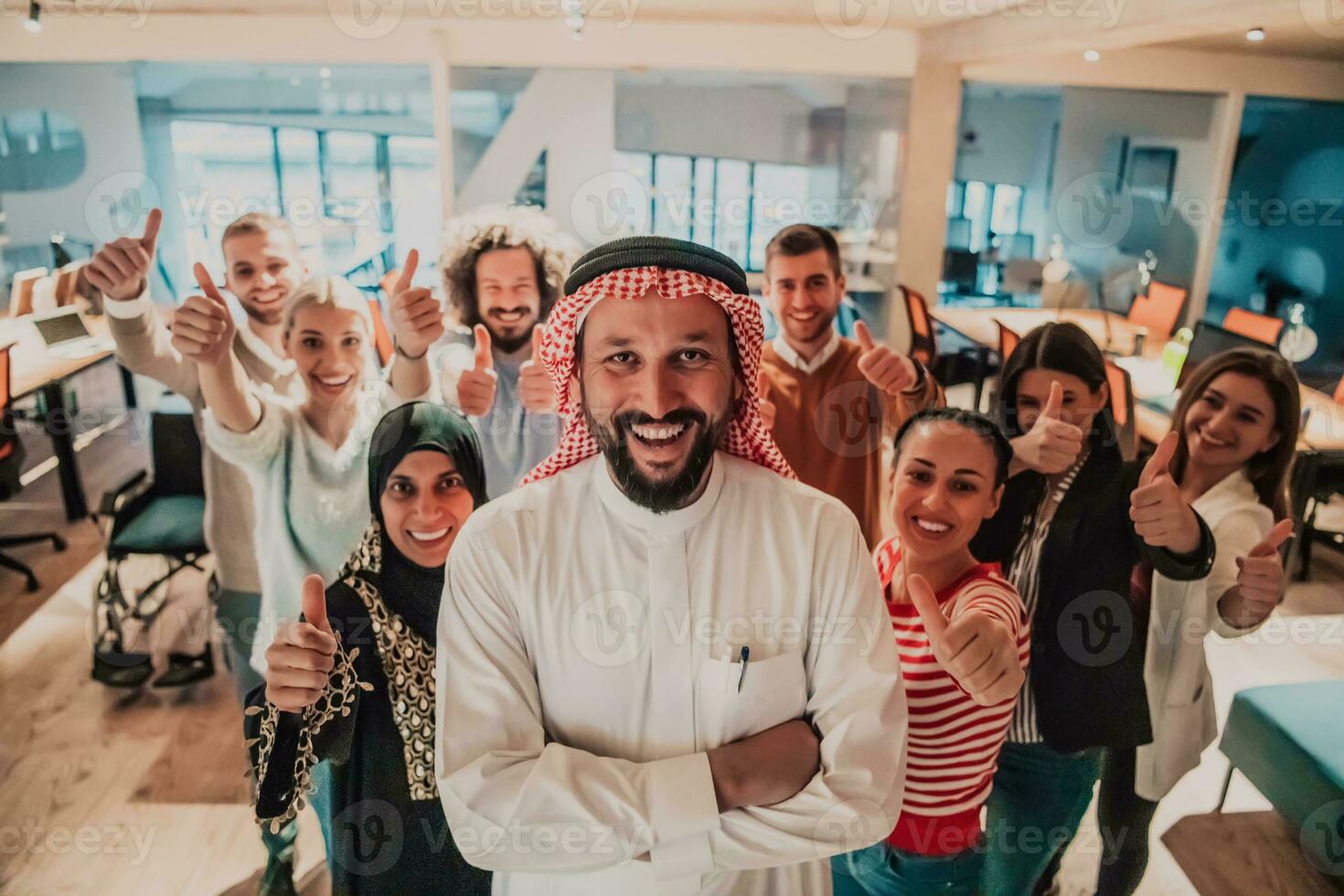 een verschillend groep van geslaagd bedrijf mensen in een modern glas kantoor staan samen Bij de top met hun Arabisch leider regisseur foto