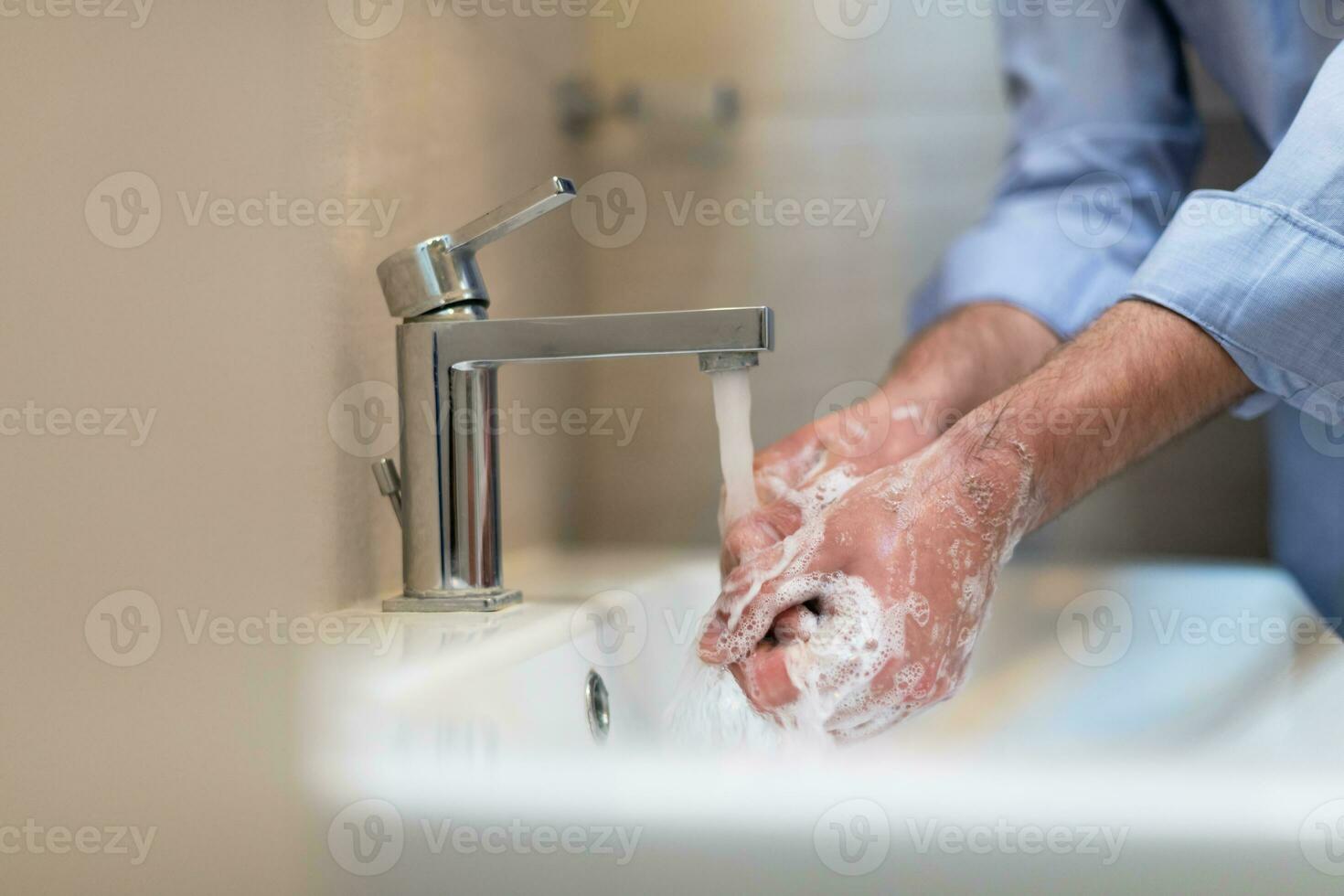 Mens gebruik makend van zeep en het wassen handen onder de water tik. hygiëne concept hand- detailopname detail. foto