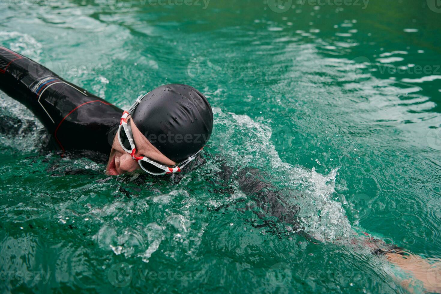 triatlonatleet die op meer zwemt die wetsuit draagt foto