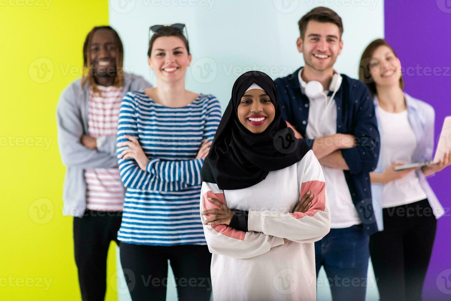 verschillend tieners gebruik makend van mobiel apparaten terwijl poseren voor een studio foto in voorkant van een kleurrijk achtergrond