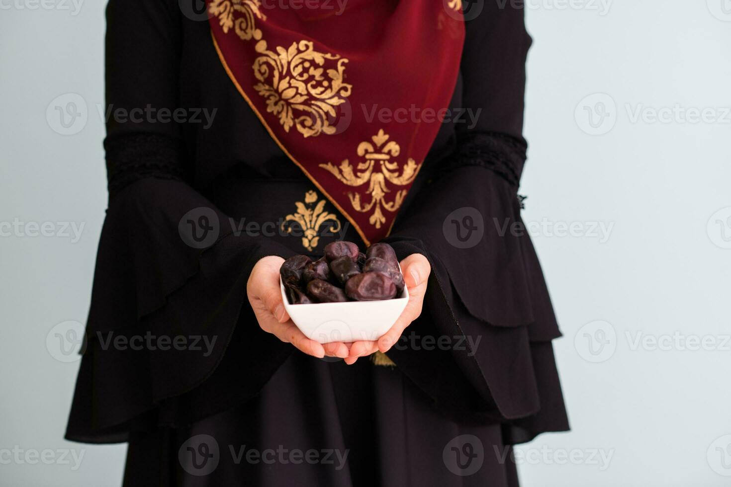 modern moslim vrouw Holding een bord vol van zoet datums Aan iftar tijd in Ramadan kareem Islamitisch gezond voedsel concept foto