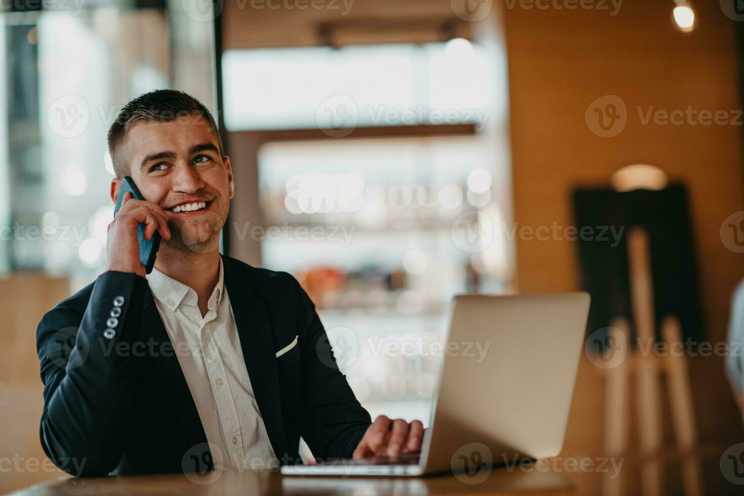 gelukkig bedrijf Mens zittend Bij cafetaria met laptop en smartphone foto