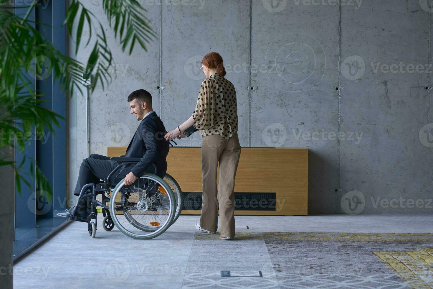 een zakenman in een rolstoel en zijn vrouw collega samen in een modern kantoor, vertegenwoordigen de macht van teamwerk, inclusie en steun, koesteren een dynamisch en inclusief werk omgeving. foto