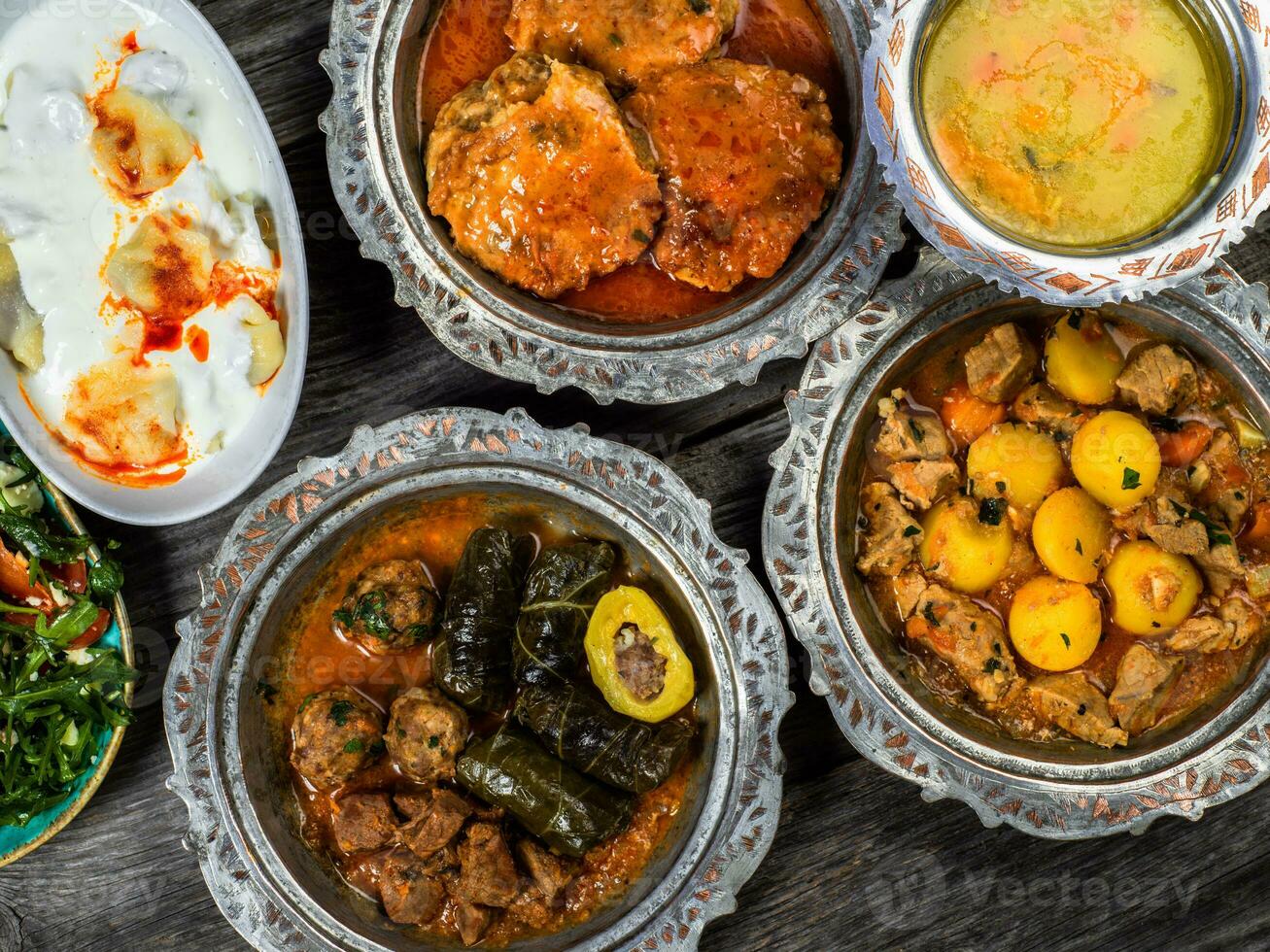 eid mubarak traditioneel Ramadan iftar diner. geassorteerd smakelijk voedsel in authentiek rustiek gerechten Aan houten blauw achtergrond. Turks Bosnisch voedsel vlees kebab, pita, sarma, klepe, zogan dolma. foto