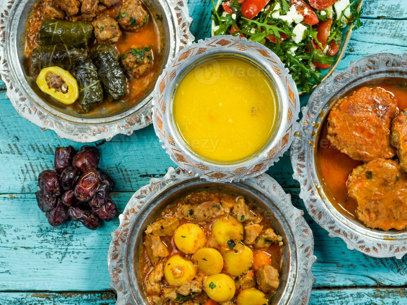 eid mubarak traditioneel Ramadan iftar diner. geassorteerd smakelijk voedsel in authentiek rustiek gerechten Aan houten blauw achtergrond. Turks Bosnisch voedsel vlees kebab, pita, sarma, klepe, zogan dolma. foto