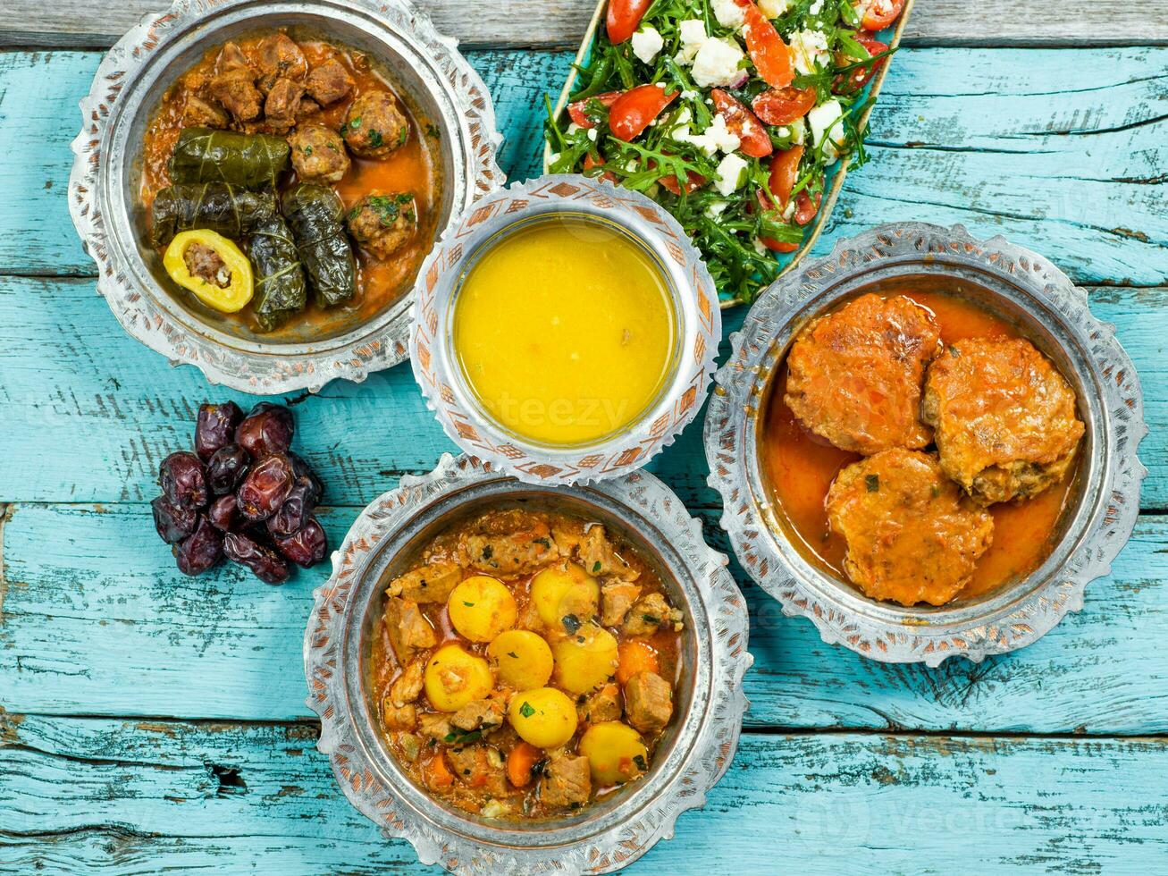 eid mubarak traditioneel Ramadan iftar diner. geassorteerd smakelijk voedsel in authentiek rustiek gerechten Aan houten blauw achtergrond. Turks Bosnisch voedsel vlees kebab, pita, sarma, klepe, zogan dolma. foto