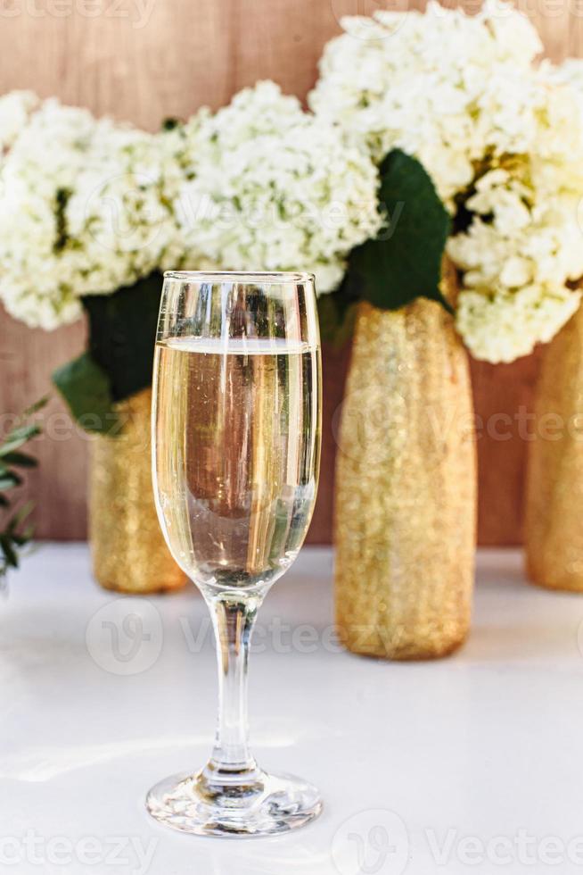 rose wijn in glazen. rose wijn op gouden flessen achtergrond foto