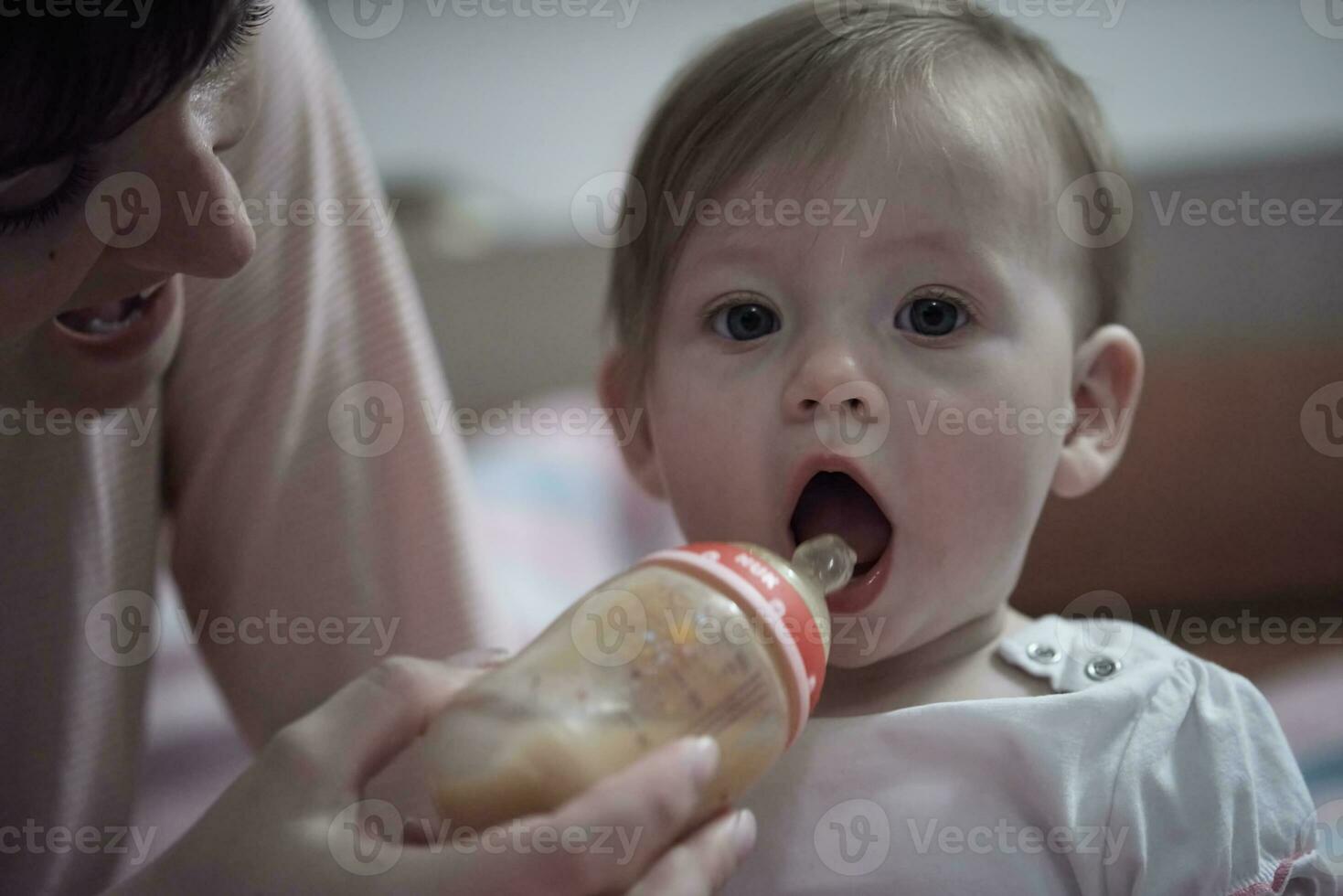 weinig baby drinken sap van fles foto