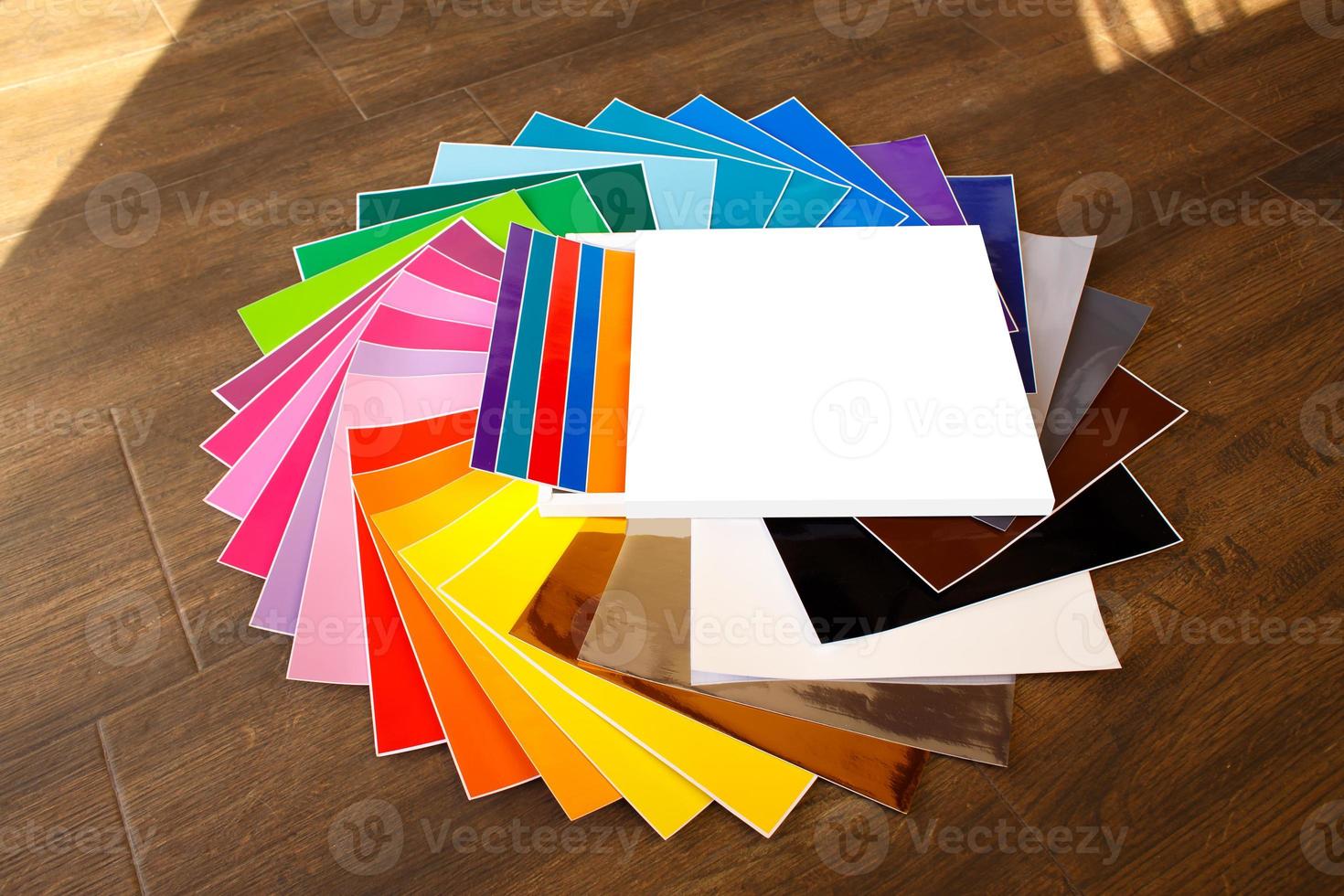 gedraaide stapel kleurrijke 12x12 vellen zelfklevend papier geïsoleerd foto