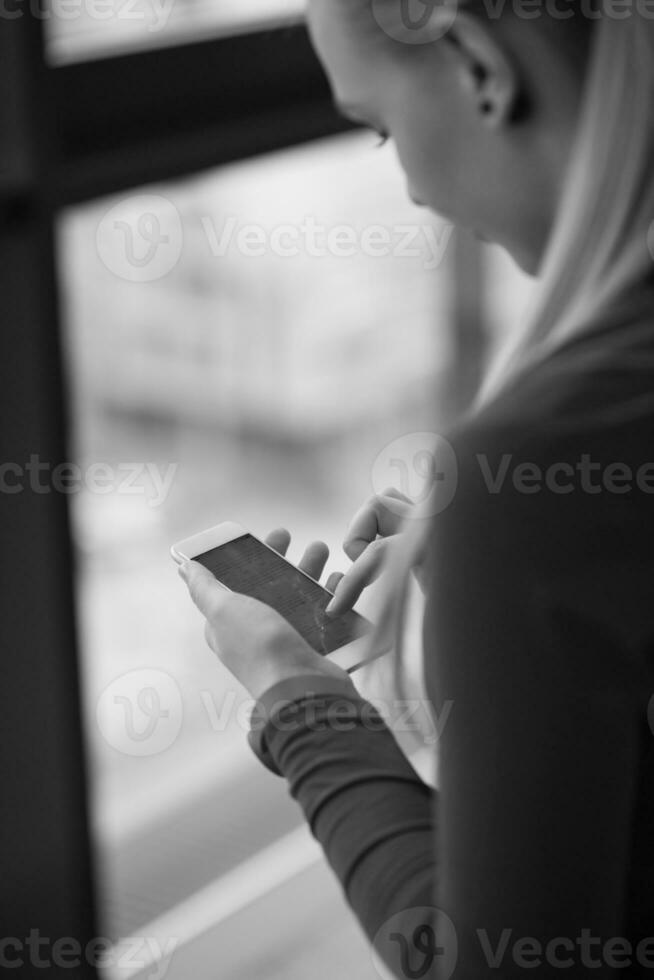 bedrijf vrouw gebruik makend van slim telefoon Bij kantoor foto