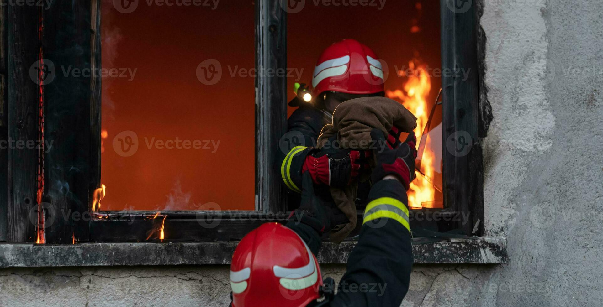 brandweerman held draag- baby meisje uit van brandend gebouw Oppervlakte van brand incident. redden mensen van gevaarlijk plaats foto