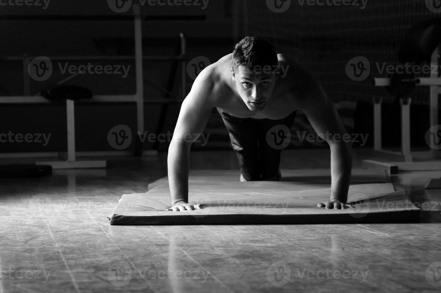 jong Mens met sterk armen werken uit in Sportschool foto