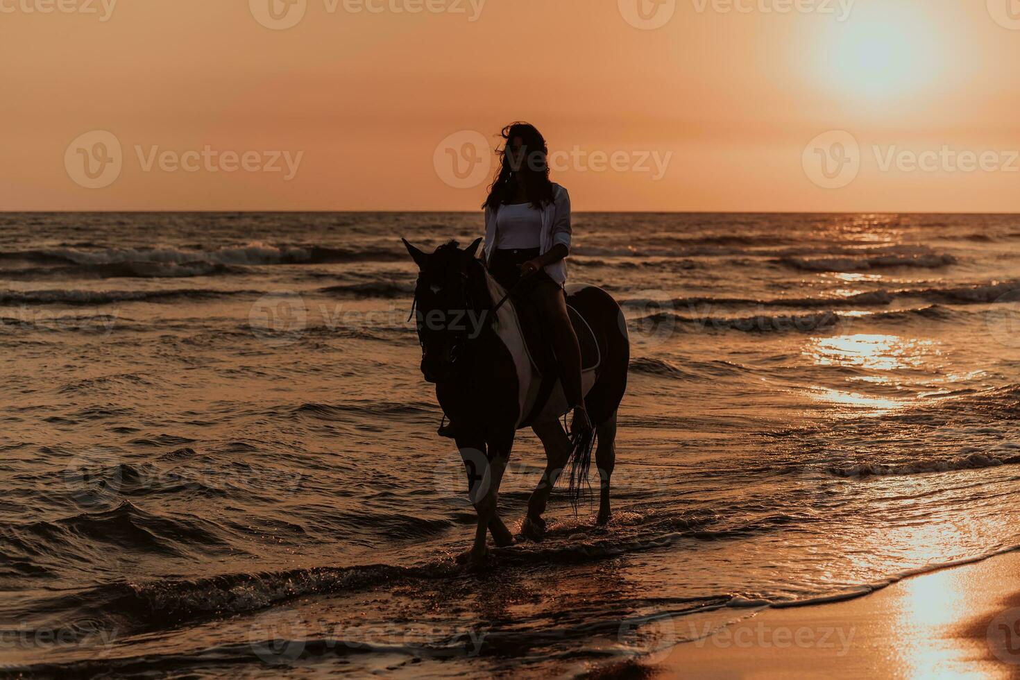 vrouw in zomer kleren geniet rijden een paard Aan een mooi zanderig strand Bij zonsondergang. selectief focus foto