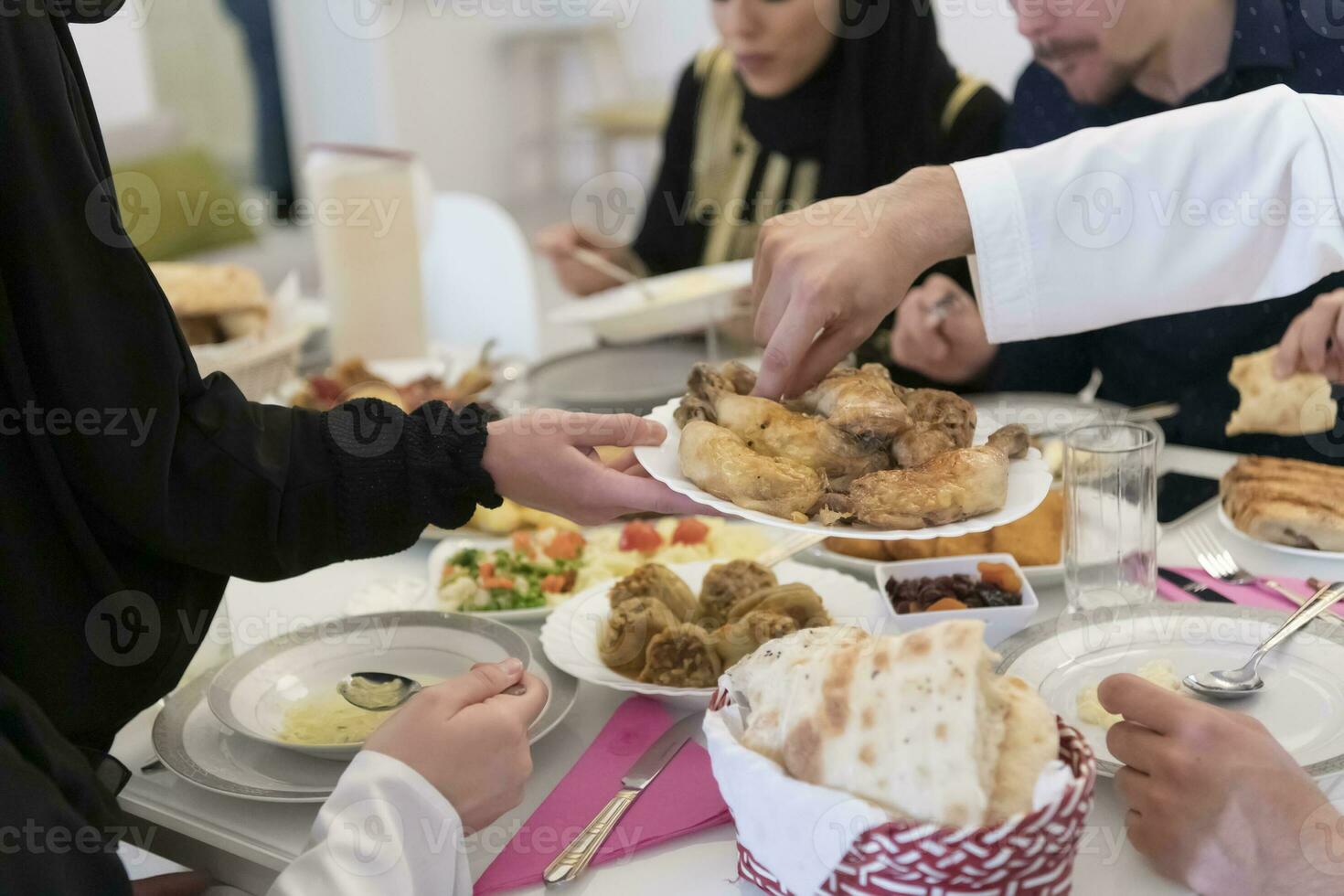 eid mubarak moslim familie hebben iftar avondeten drinken water naar breken feest. aan het eten traditioneel voedsel gedurende Ramadan feesten maand Bij huis. de Islamitisch halal aan het eten en drinken Bij modern western isla foto