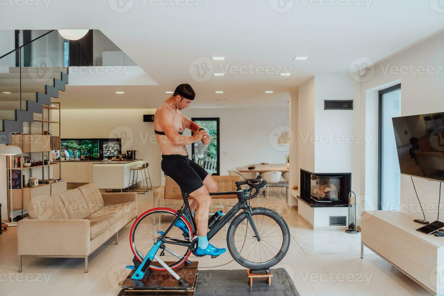 een Mens rijden een triatlon fiets Aan een machine simulatie in een modern leven kamer. opleiding gedurende pandemisch conditie. foto