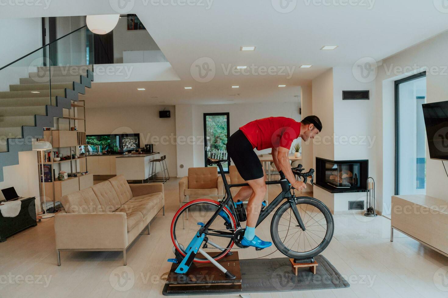 een Mens rijden een triatlon fiets Aan een machine simulatie in een modern leven kamer. opleiding gedurende pandemisch conditie. foto