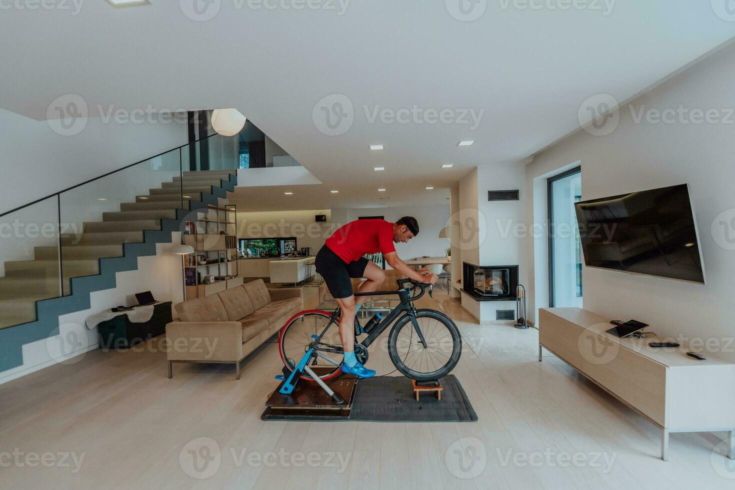 een Mens rijden een triatlon fiets Aan een machine simulatie in een modern leven kamer. opleiding gedurende pandemisch conditie. foto