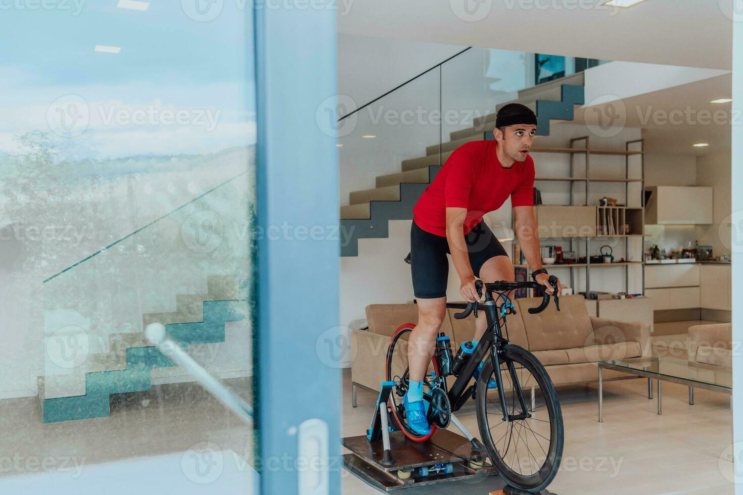 een Mens rijden een triatlon fiets Aan een machine simulatie in een modern leven kamer. opleiding gedurende pandemisch conditie. foto