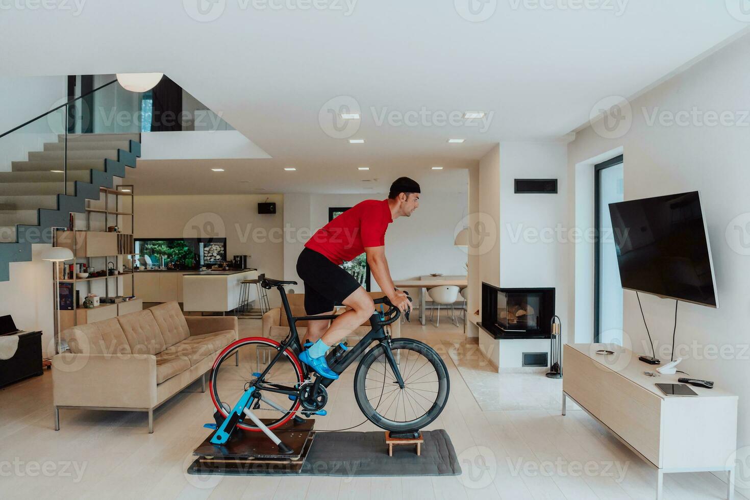 een Mens rijden een triatlon fiets Aan een machine simulatie in een modern leven kamer. opleiding gedurende pandemisch conditie. foto