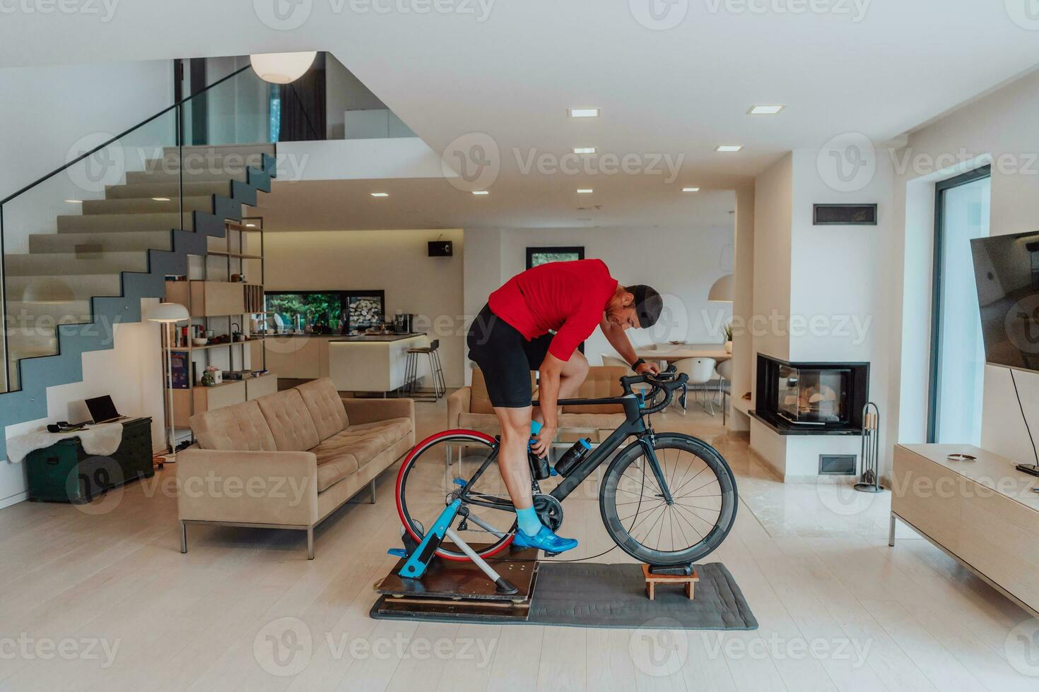 een Mens rijden een triatlon fiets Aan een machine simulatie in een modern leven kamer. opleiding gedurende pandemisch conditie. foto