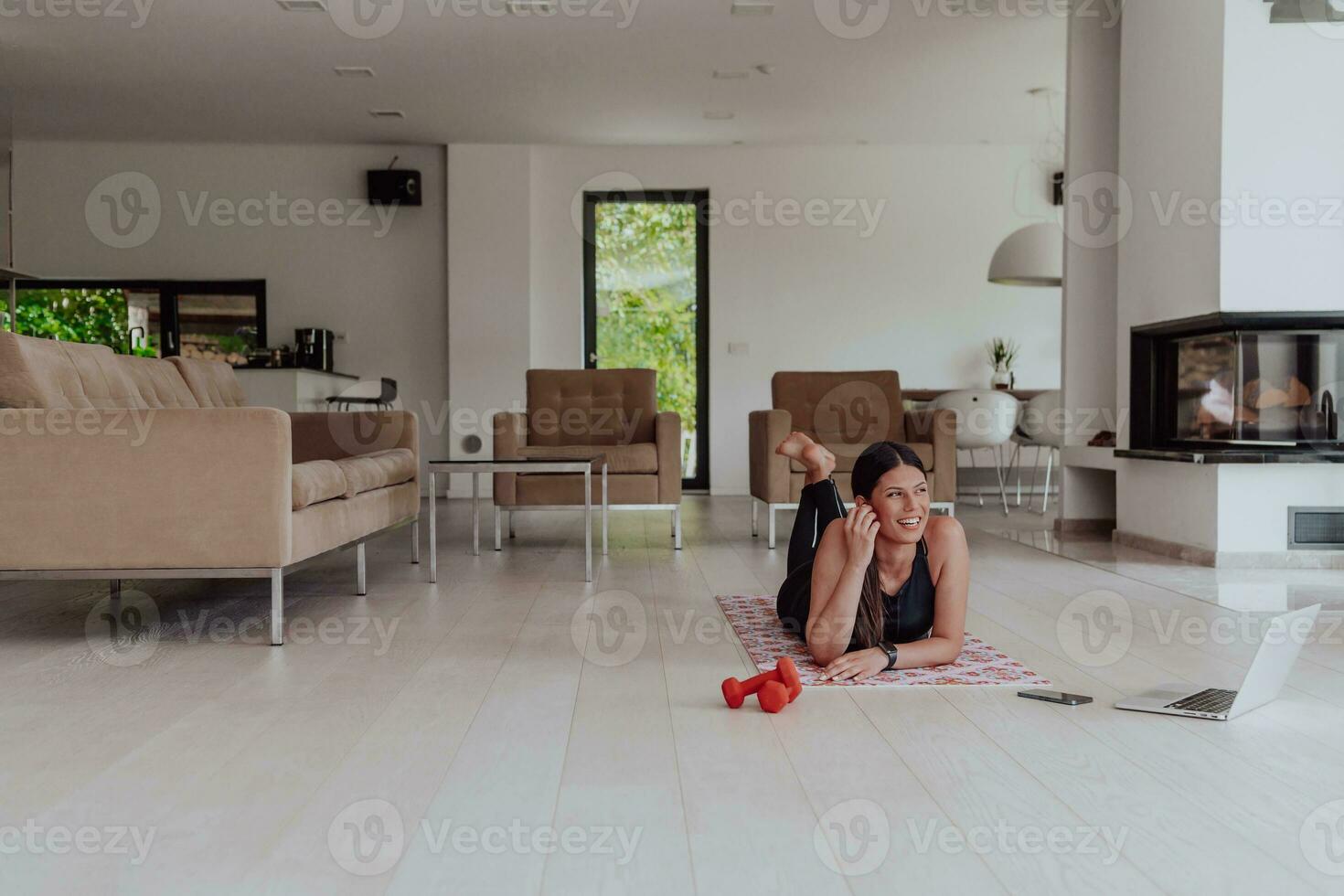 jong vrouw resting na online opleiding terwijl aan het liegen Aan de leven kamer verdieping foto