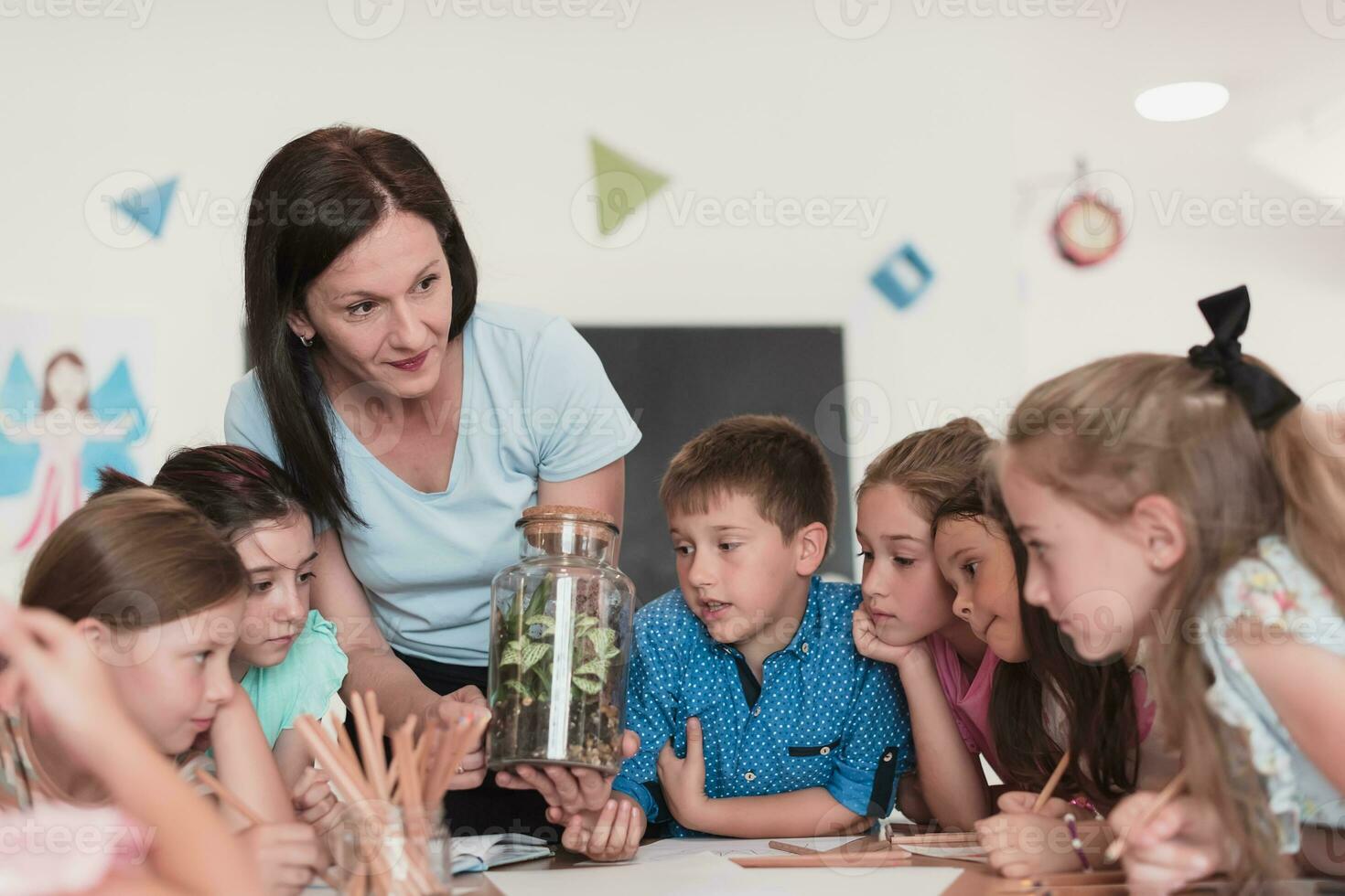 vrouw leraar met kinderen in biologie klasse Bij elementair school- dirigeren biologie of botanisch wetenschappelijk experiment over duurzame groeit planten. aan het leren over planten in een glas pot foto