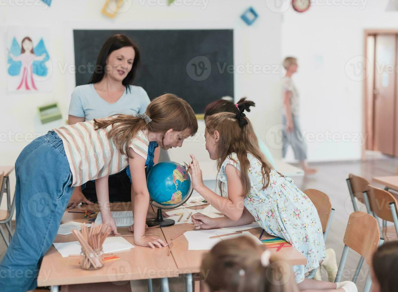 vrouw leraar met kinderen in aardrijkskunde klasse op zoek Bij wereldbol. kant visie van groep van verschillend gelukkig school- kinderen met wereldbol in klas Bij school. foto