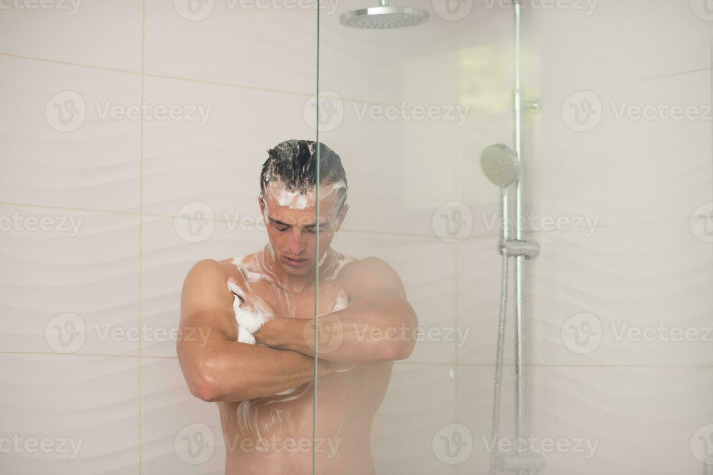 Mens nemen douche in bad foto