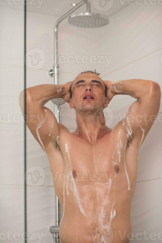 Mens nemen douche in bad foto