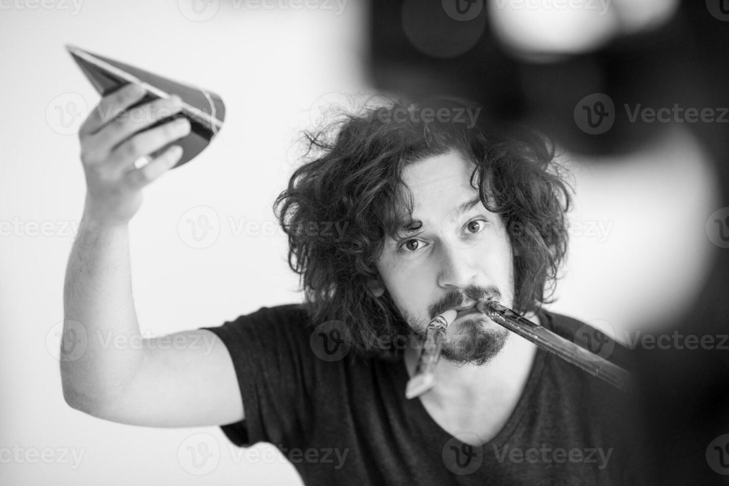 portret van een man met een feestmuts die op een fluitje blaast foto