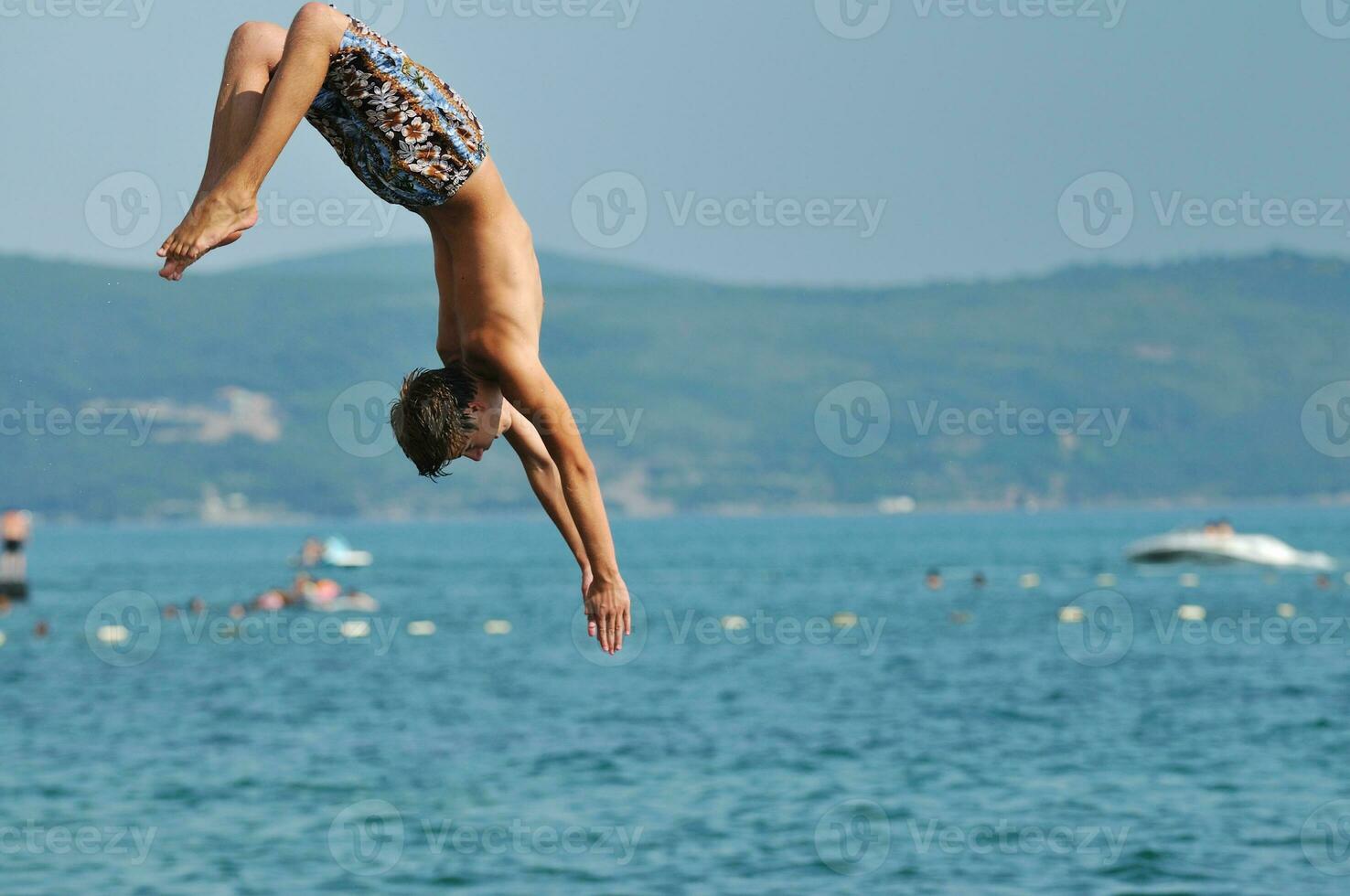 jongen springen zee foto