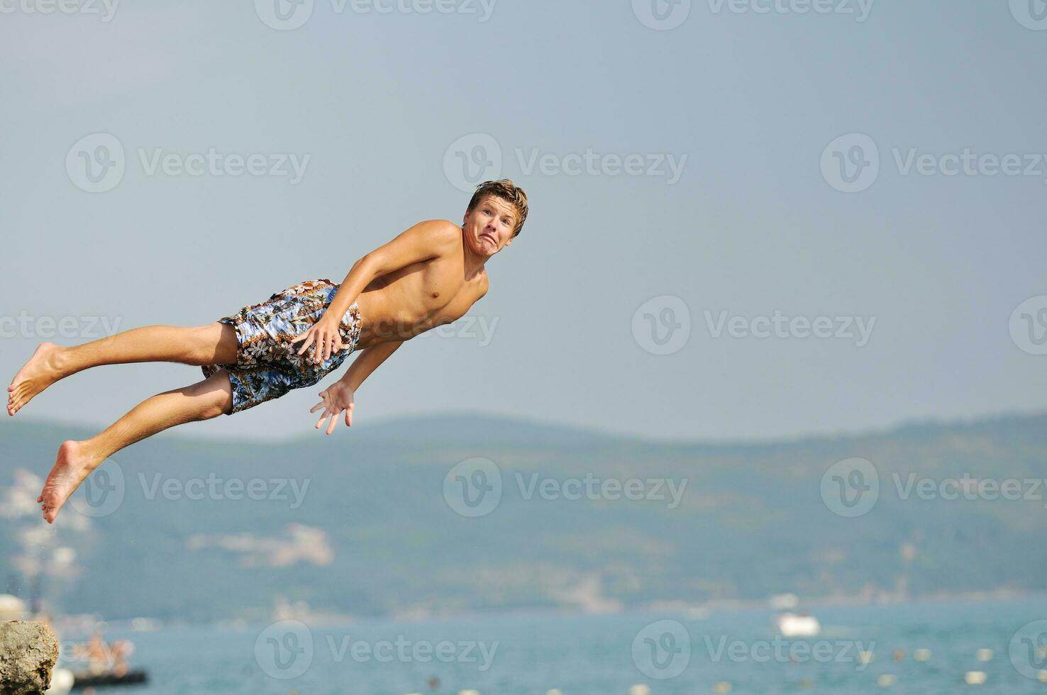 jongen springen zee foto