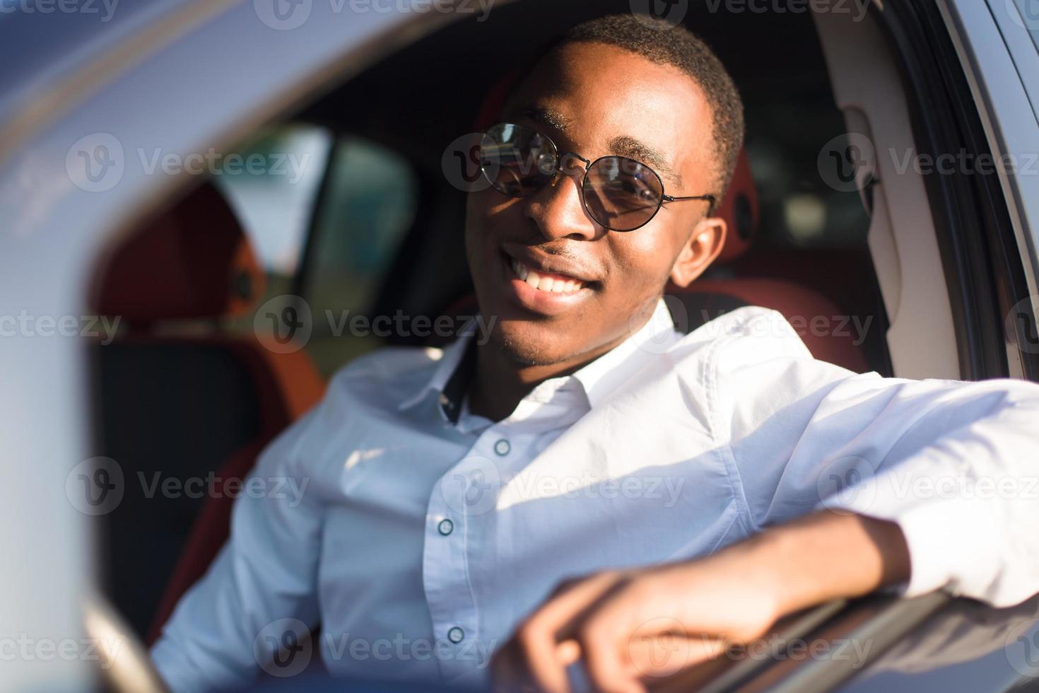 gelukkige Afro-Amerikaan die een auto bestuurt, in de zomer foto