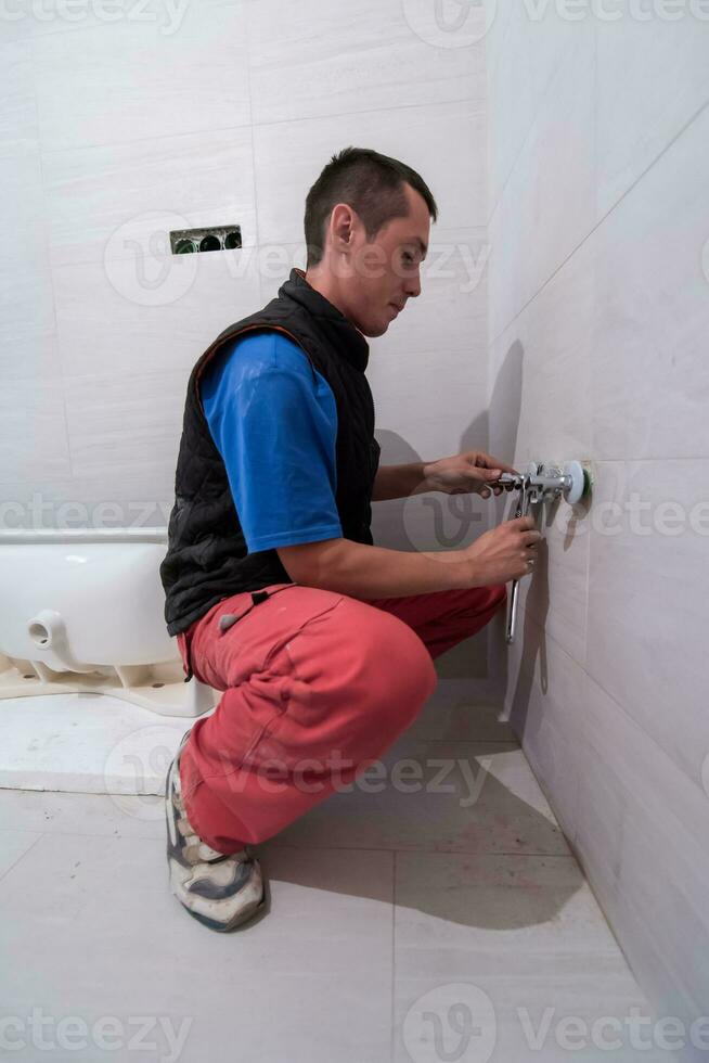 professioneel loodgieter werken in een badkamer foto