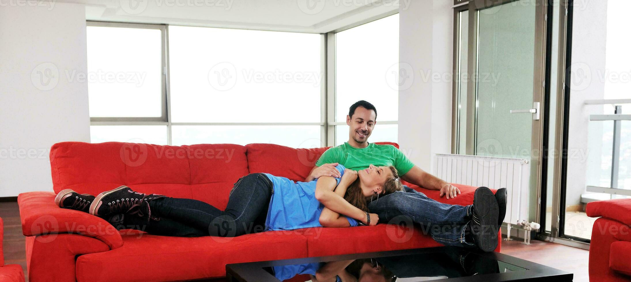 gelukkig paar kom tot rust Aan rood sofa foto