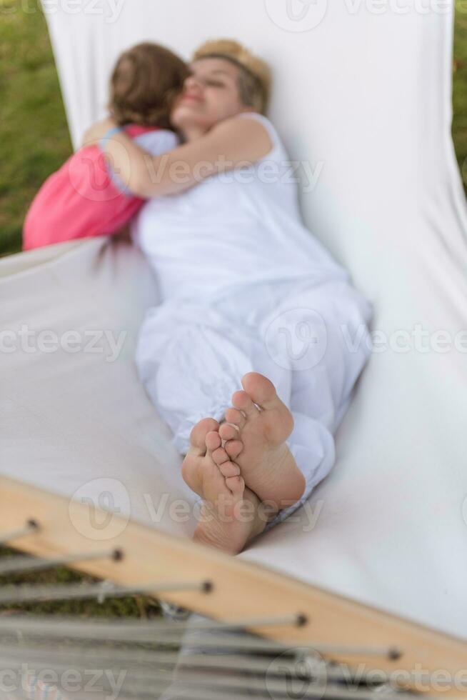 moeder en een weinig dochter ontspannende in een hangmat foto
